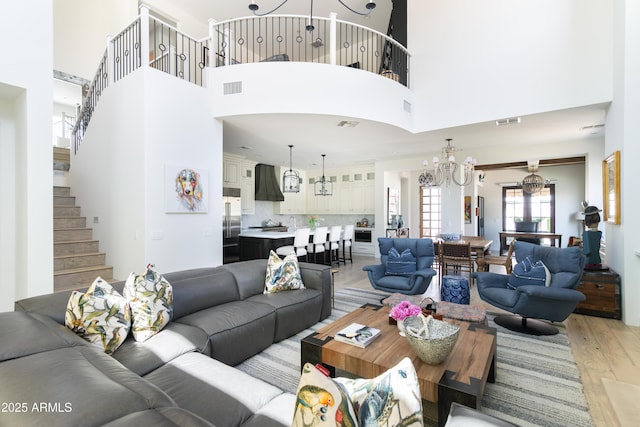 3511 N 39th Pl, Phoenix, AZ 85018 - living room with light wood-style flooring, a chandelier, a towering ceiling, and stairs