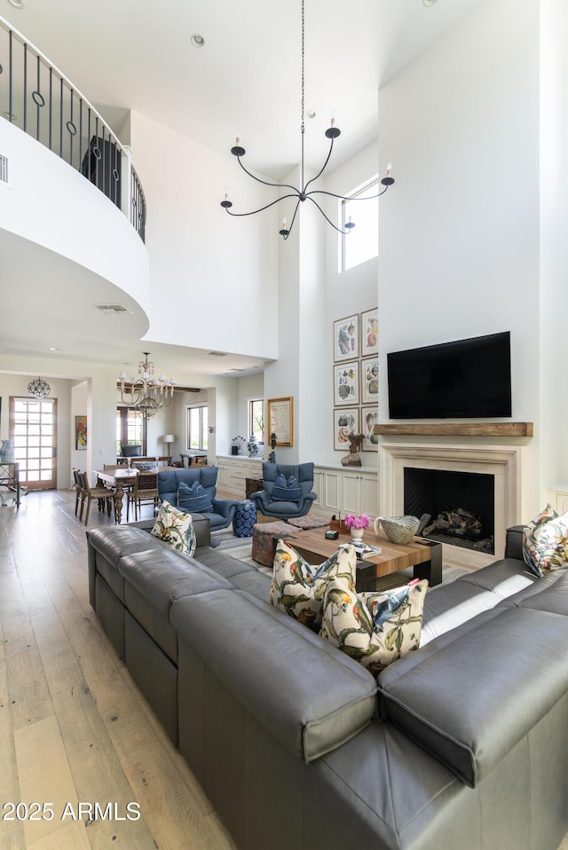 3511 N 39th Pl, Phoenix, AZ 85018 - living area featuring a chandelier, a towering ceiling, light wood finished floors, and a fireplace