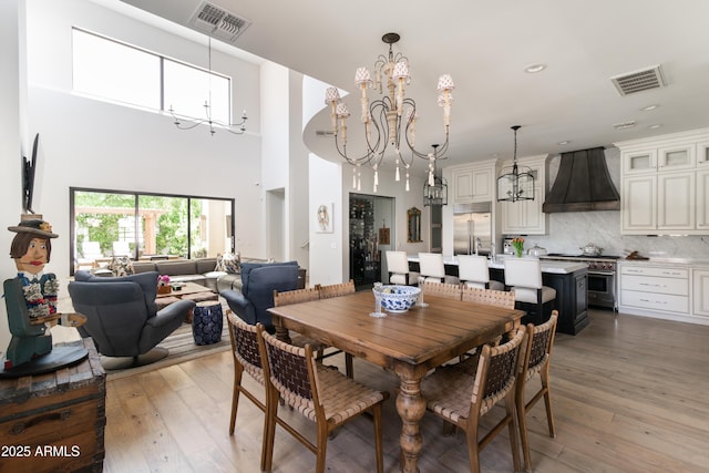 3511 N 39th Pl, Phoenix, AZ 85018 - dining area with a chandelier, a towering ceiling, light wood-style flooring, and recessed lighting