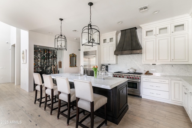 3511 N 39th Pl, Phoenix, AZ 85018 - kitchen with high quality appliances, custom range hood, a chandelier, an island with sink, and backsplash