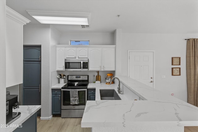 470 N 168th Ln, Goodyear, AZ 85338 - kitchen featuring visible vents, a sink, appliances with stainless steel finishes, white cabinetry, and light wood-type flooring