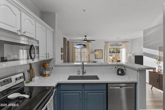 470 N 168th Ln, Goodyear, AZ 85338 - kitchen featuring blue cabinets, a sink, stainless steel appliances, a peninsula, and white cabinets