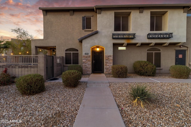 470 N 168th Ln, Goodyear, AZ 85338 - view of front facade with a gate, fence, stone siding, and stucco siding