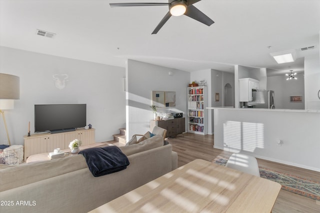470 N 168th Ln, Goodyear, AZ 85338 - living room featuring visible vents, stairs, light wood-type flooring, and a ceiling fan