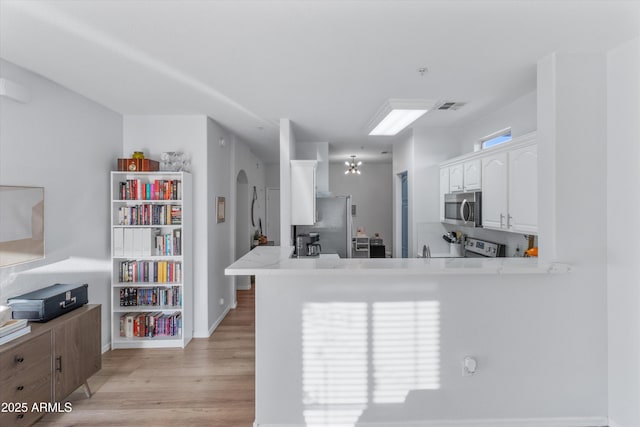 470 N 168th Ln, Goodyear, AZ 85338 - kitchen with visible vents, light wood-type flooring, light countertops, appliances with stainless steel finishes, and white cabinetry