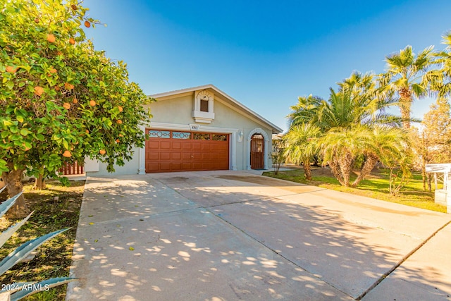 view of front of house featuring concrete driveway, an attached garage, and stucco siding