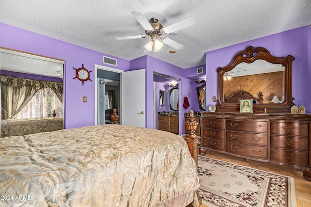 bedroom with a textured ceiling, ceiling fan, and visible vents