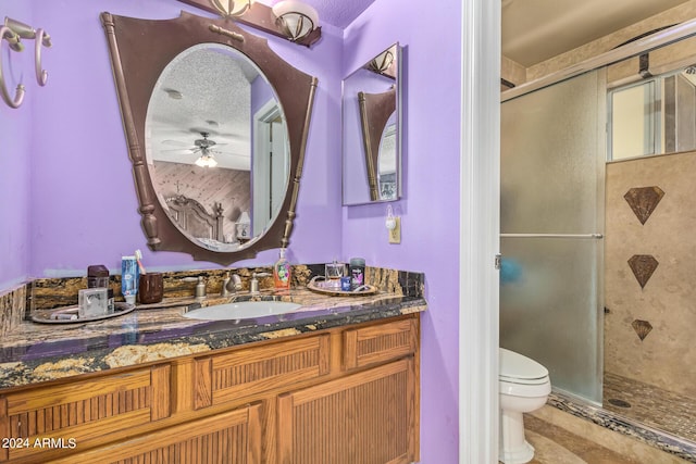 full bathroom featuring toilet, a textured ceiling, a shower stall, vanity, and tile patterned floors