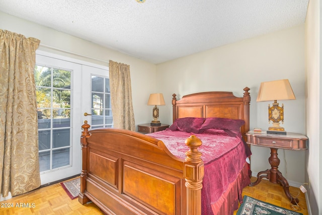 bedroom featuring access to outside, french doors, and a textured ceiling