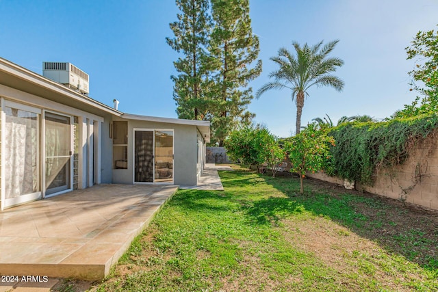 view of yard with a fenced backyard, a patio, and central AC