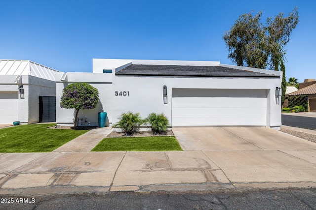 view of front of property with an attached garage, driveway, and stucco siding