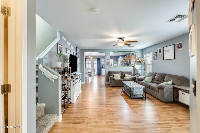 living room with light wood-type flooring and ceiling fan