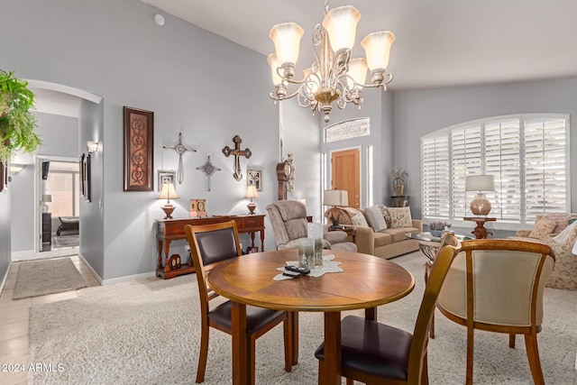 carpeted dining area with a notable chandelier