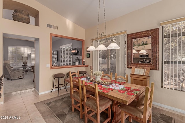 dining room with lofted ceiling and tile patterned floors