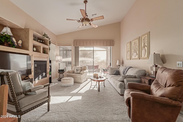 living room with lofted ceiling, ceiling fan, light carpet, and a tile fireplace