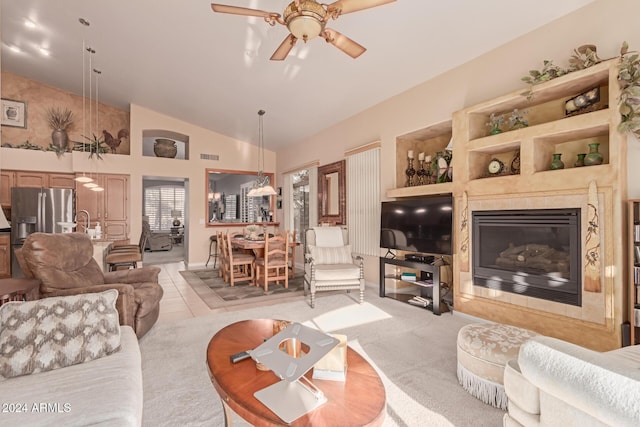 living room featuring a fireplace, built in features, ceiling fan, and vaulted ceiling