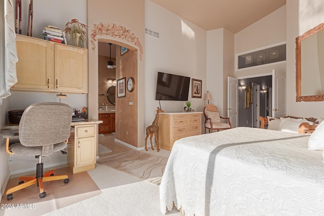 bedroom with vaulted ceiling, light colored carpet, and ensuite bath