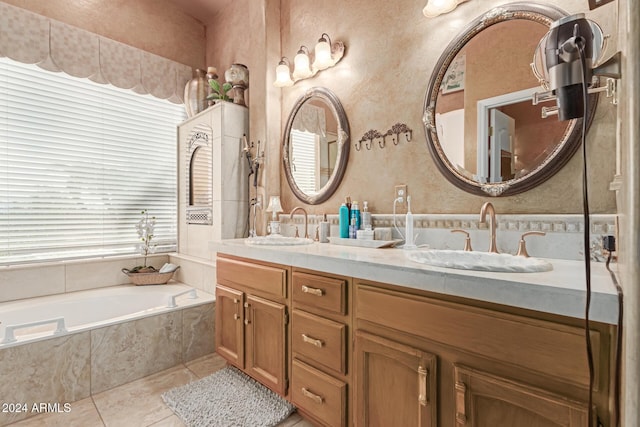 bathroom featuring a relaxing tiled tub, tile patterned floors, vanity, and a healthy amount of sunlight