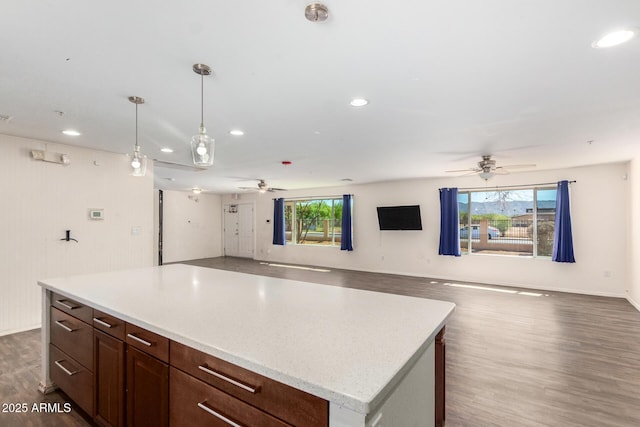 kitchen with recessed lighting, open floor plan, a center island, dark wood-style floors, and decorative light fixtures