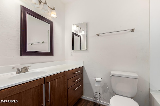 full bathroom with toilet, wood finished floors, and vanity