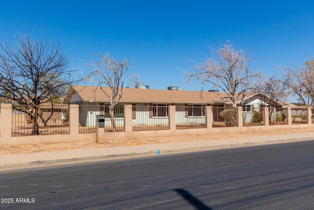 ranch-style home with a fenced front yard