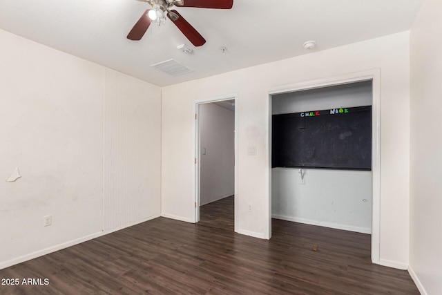 unfurnished bedroom with dark wood-type flooring, visible vents, baseboards, and a ceiling fan