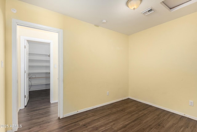 unfurnished room with dark wood-style floors, baseboards, and visible vents