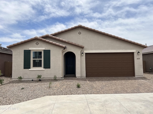 40559 W Rio Grande Dr, Maricopa, AZ 85138 - mediterranean / spanish-style home with decorative driveway, an attached garage, a tile roof, and stucco siding