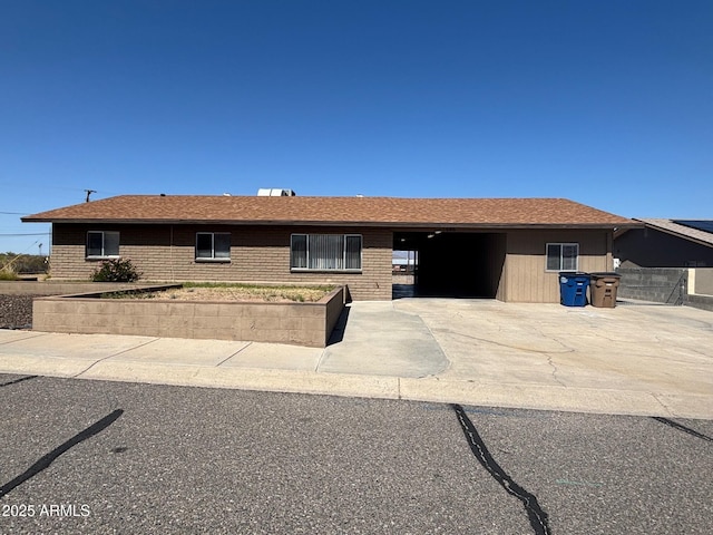 ranch-style house with an attached garage, concrete driveway, and a shingled roof