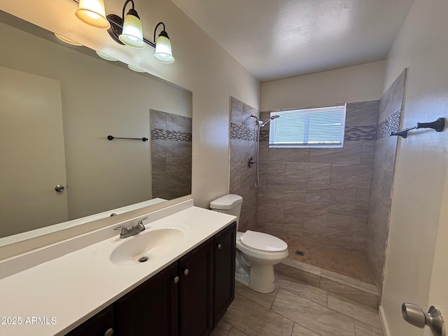 full bath with toilet, vanity, and a tile shower