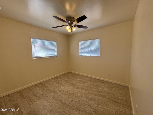 spare room featuring baseboards and a ceiling fan