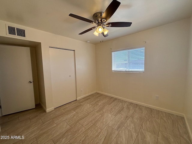 unfurnished bedroom with a closet, visible vents, a ceiling fan, and baseboards