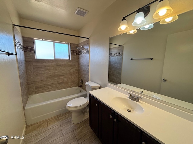 full bathroom featuring visible vents, toilet, vanity, and washtub / shower combination