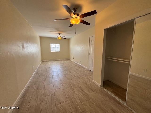 unfurnished bedroom with a closet, baseboards, ceiling fan, and wood tiled floor