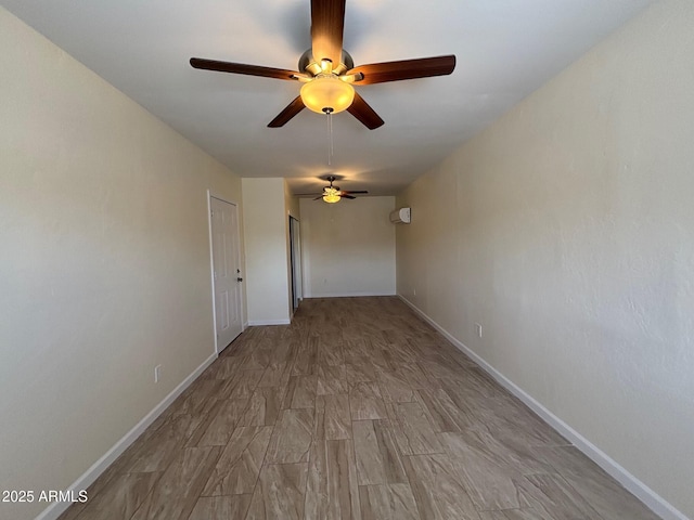 spare room with baseboards and wood finished floors