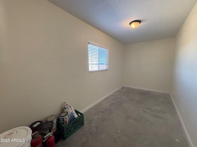 empty room with concrete flooring and baseboards