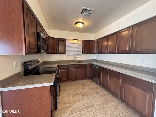 kitchen with dark brown cabinetry, visible vents, appliances with stainless steel finishes, and a sink