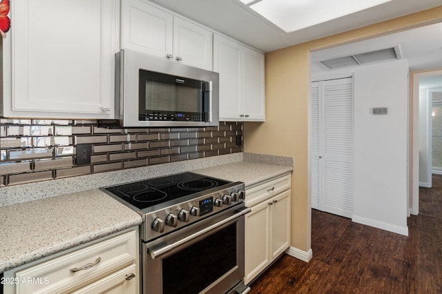 kitchen with stainless steel appliances, dark wood-type flooring, decorative backsplash, baseboards, and light stone counters