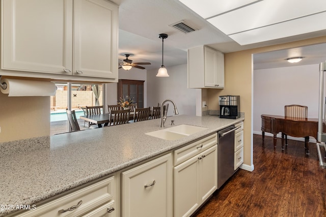 kitchen featuring a sink, dishwasher, ceiling fan, and light stone counters