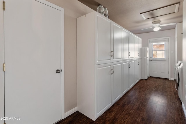 corridor with washing machine and clothes dryer, dark wood-style floors, and baseboards