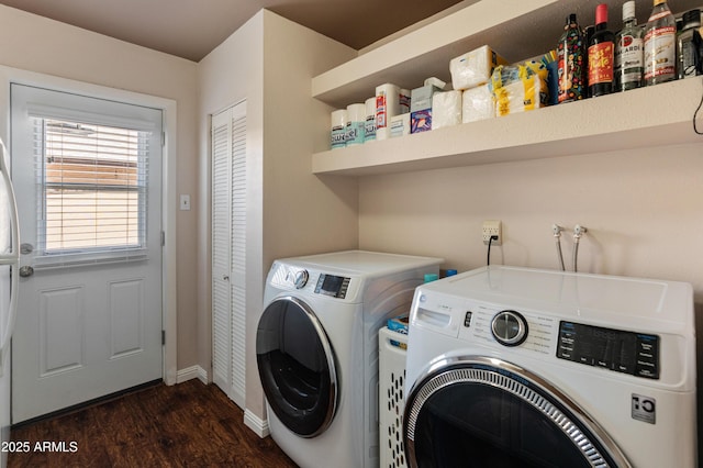 clothes washing area with independent washer and dryer, dark wood finished floors, and baseboards