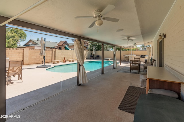 view of pool with a fenced backyard, a patio area, outdoor dining area, ceiling fan, and a diving board