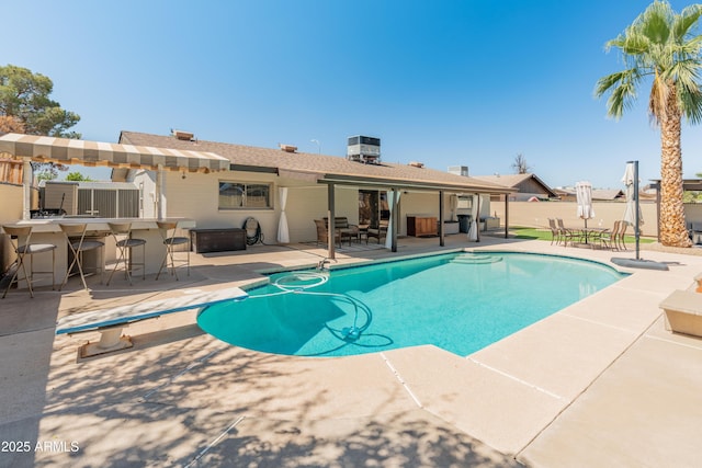 view of pool with a patio area, fence, and a diving board