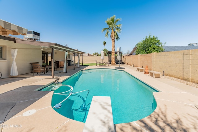 view of pool featuring a patio, a fenced backyard, a diving board, and central AC