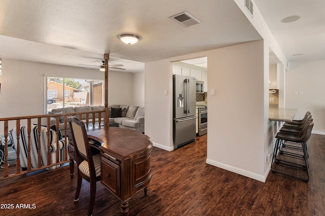 dining area featuring dark wood-type flooring, ceiling fan, and baseboards