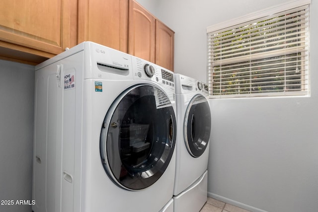 laundry area featuring baseboards, cabinet space, washing machine and clothes dryer, and light tile patterned flooring