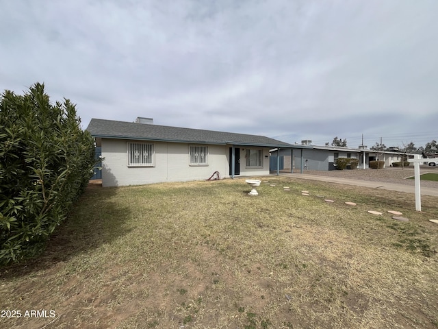 single story home with a front yard and concrete block siding