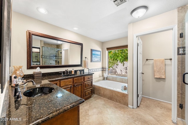 full bath featuring visible vents, a sink, a shower stall, and double vanity