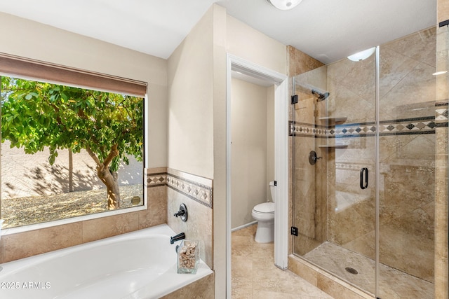 bathroom featuring a stall shower, tile patterned flooring, a garden tub, and toilet