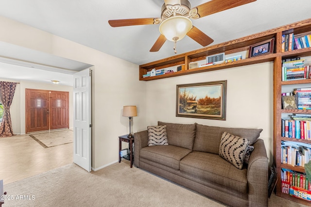 living area featuring ceiling fan, carpet floors, and baseboards